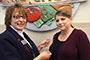Sara Weller, accounts payable clerk, receives her commemorative 70th anniversary pin from ACES Director of Human Resources Christina Loper.