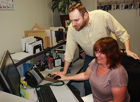 James Reese and Kelly Harrison at a computer and desk