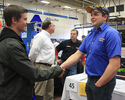 representative from Lamb & Webster Inc. shakes hands with a student