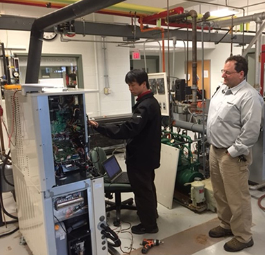 Yanmar engineers Yoshinori Jodo, left, and Michael Alfano inspecting the installation of the micro combined heat and power (Micro CHP) system