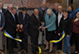 several people standing behind a ribbon being cut