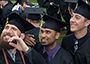 three male students at Commencement taking a selfie