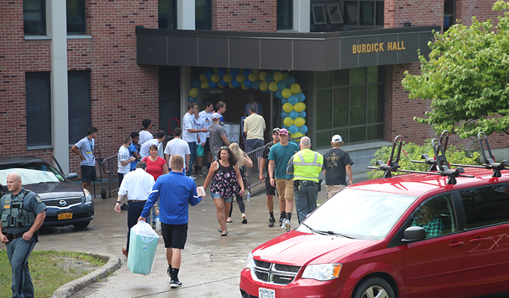 red van, people moving items into Burdick Hall, yellow and blue balloons