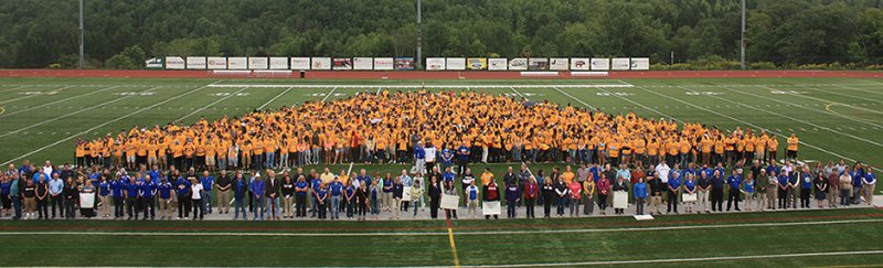students, faculty, and staff in Pioneer Stadium create a human Alfred State logo