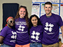 four students wearing purple shirts
