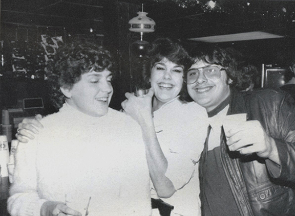 three students gather at Pioneer Pub in 1985 holding drinks