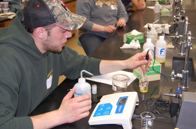 student Tyler Ross measures pH on a soil sample 