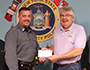 Lt. Scott Bingham presents Rod Ballengee a check