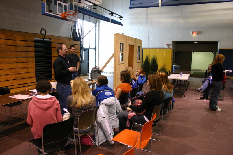picture from WINS Futurebound Day, male standing in front of students sitting at tables in gymnasium