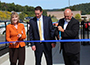 Athletic director, President Sullivan, and Senator Catharine Young outside cutting the blue ribbon