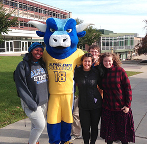 Big Blue ox standing on campus with four students